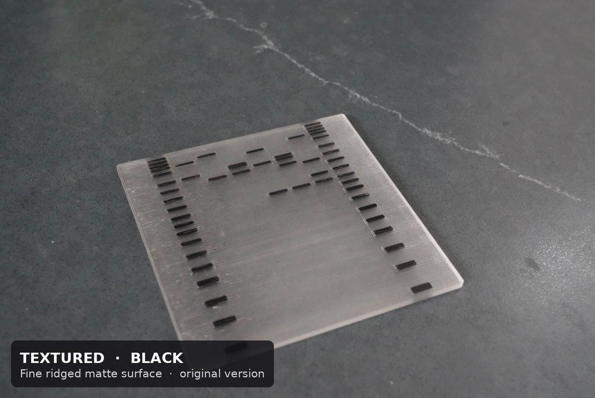 Textured DNA gel coaster with black ladder and sample bands on a gray stone surface