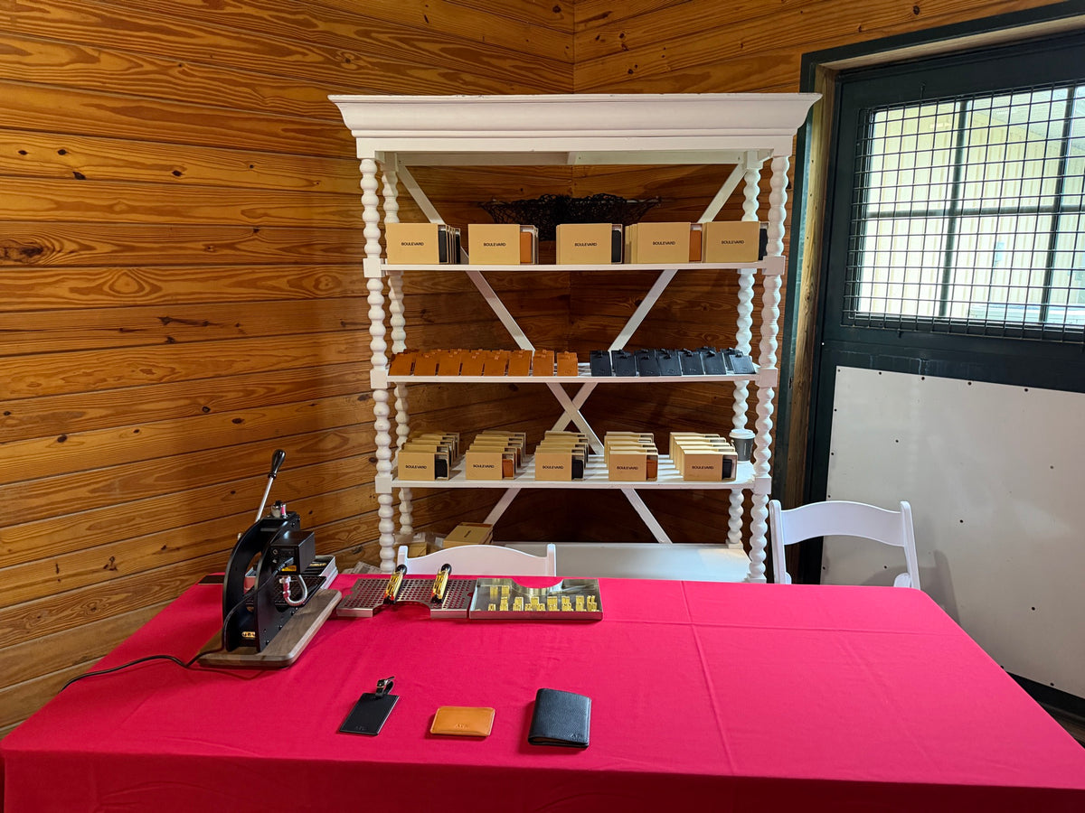 Hurst Product Lab live leather monogramming station with an embossing press and personalized leather luggage tags, card holders and wallets at a Twilio event